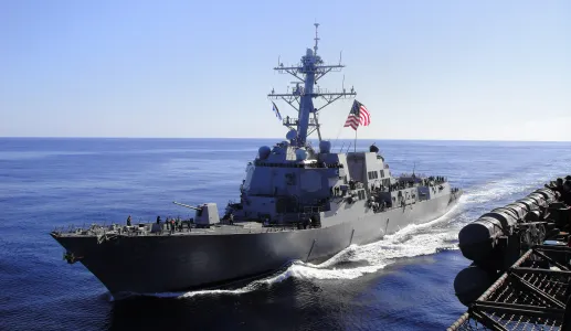 Imagem de um barco da marinha americana, com uma bandeira dos EUA hasteada.