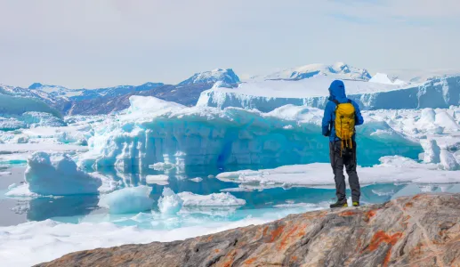 Um homem, explorador, olha para um icebergue no Ártico. Crédito: Shutterstock