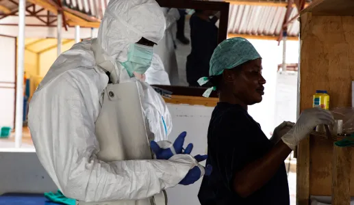 Imagem de uma enfermeira e de um médico vestidos com equipamentos de segurança durante um surto de Ébola em África. Belen B. Massieu/shutterstock