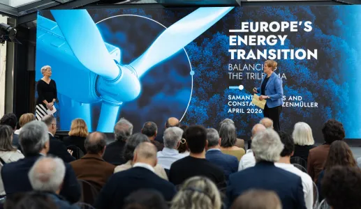 Uma plateia de costas a assistir à apresentação de duas mulheres, num palco. Texto "Europe's Energy Transition".