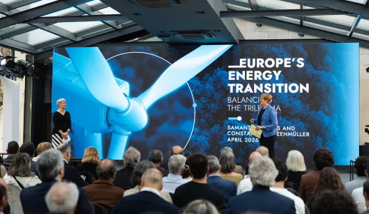 Uma plateia de costas a assistir à apresentação de duas mulheres, num palco. Texto "Europe's Energy Transition".
