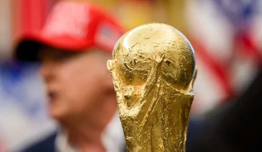 Imagem do troféu do Mundial 2026 em foco e, ao fundo, desfocado, Donald Trump. Créditos: shutterstock