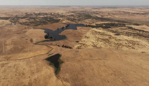 Imagem aérea de vários terrenos áridod r algumas manchas de água.
