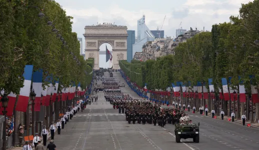 Desfile na avenida Champs-Elysees, em Paris, no dia da Bastilha. Soldados a desfilar e várias bandeiras do país.