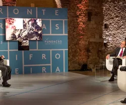 O jornalista Carlos Daniel a moderar um painel composto por Paulo Portas e outros três convidados. Ao fundo, o texto "Fronteiras XXI".