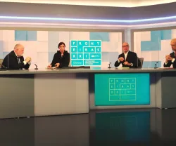 Quatro pessoas sentadas à volta de uma mesa mesa num estúdio de televisão. Ao fundo, o texto "FRONTEIRAS XXI".