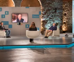 Imagem de um painel de discussão com cinco pessoas, incluindo uma em videochamada.