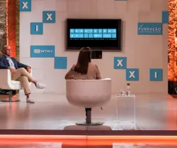 Discussão em painel com quatro pessoas, tela ao fundo com o texto "Fronteiras XXI".