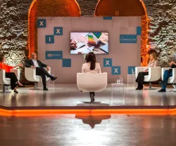 Debate com cinco pessoas em cadeiras brancas. Ao fundo, o logo da Fundação.