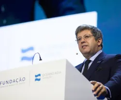 José Soares dos Santos a falar num púlpito com os textos "FUNDAÇÃO" e "OCENO AZUL" visíveis.