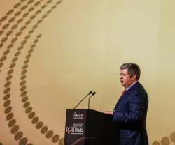 José Soares dos Santos, de fato cinza, a falar ao microfone num púlpito, que tem escrito "DESAFIAR PORTUGAL".