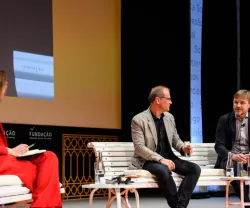 Painel de discussão com três pessoas.