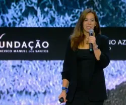 Mulher de pé a falar num palco. Texto projetado numa tela ao fundo: "FUNDAÇÃO FRANCISCO MANUEL DOS SANTOS".