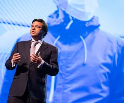 Gonçalo Saraiva Matias,de fato, a discursar. Fundo com uma imagem de uma pessoa de máscara e casaco.