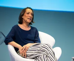 Ana Santos Pinto, especialista em geopolítica, a falar, sentada numa cadeira branca.