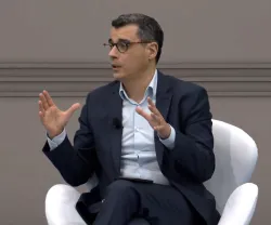 O jornalista Luís Rosa, sentado numa cadeira branca, a falar e a gesticular.