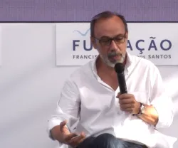 João Seixas, professor e investigador na NOVA FCSH, sentado, a falar com um microfone na mão.