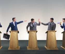 Cinco homens de fato em debate, cada um atrás de um púlpito, com expressões variadas.