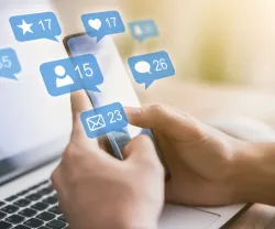 Pessoa segurando um smartphone com notificações digitais sobrepostas.