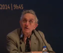Richard Rose sentado a falar para um microfone.