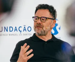 Homem com óculos e barba, a falar durante um evento, com o logo da Fundação Francisco Manuel dos Santos.