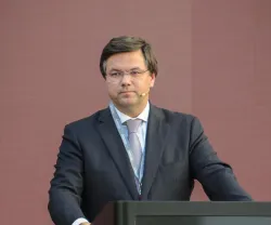 Gonçalo Saraiva Matias, de fato, a discursar num púlpito. Fundo rosa claro.
