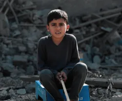 Imagem de uma criança palestiniana na Faixa de Gaza, no meio de destroços