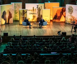Plateia sentada a olhar para o palco, onde está o historiador Simon Sebag Montefiore a ser entrevistado, na Aula Magna.