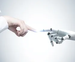 Uma mão humana e de uma mão robótica quase a tocarem-se.