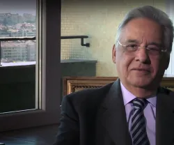 O antigo presidente do Brasil, Fernando Henrique, sentado. Ao fundo, uma janela com vista para a cidade.