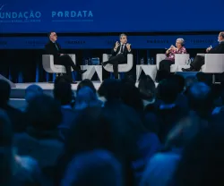 Debate em palco com quatro pessoas sentadas, atrás de uma plateia, com os logos da Fundação e da Pordata.