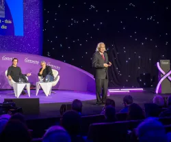 Michio Kaku num palco a discursar, de fato, para uma plateia. 