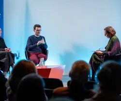 Debate com três pessoas em palco, durante a apresentação de um livro da Fundação.