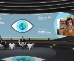 Entrevista virtual, com dois homens sentados em cadeiras num estúdio, e a historiadora de Ciência Naomi Oreskes a falar, numa tela, com o texto "DE OLHOS POSTOS NO PLANETA" e o logotipo da Fundação.
