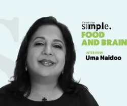 Retrato a preto e branco da psiquiatra nutricional Uma Naidoo sobre um fundo azul claro. Texto: "It's not that simple. Food and Brain. Interview".