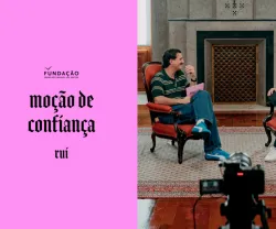 Guilherme Geirinhas sentado ao lado de Rui Rocha enquanto conversam. Texto "moção de confiança" â esquerda.