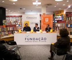 Apresentação de um livro numa livraria, com três oradores e banners da Fundação.