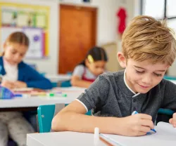 Alunos do ensino básico na sala de aula a fazer testes. Crédito:Shutterstock
