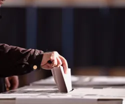 Imagem de um senhor a colocar o voto numa urna