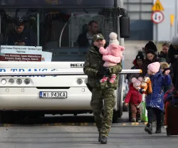 Imagem de um grupo de refugiados ucranianos, a maioria mulheres com crianças, a cruzar a fronteira com a Polónia. Crédito: Shutterstock
