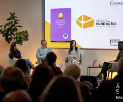 Quatro pessoas sentadas no palco, com uma plateia a assistir, e um ecrã que tem a capa de um livro da Fundação.