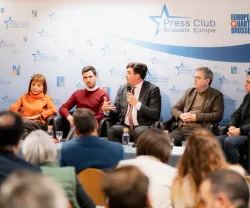 Uma plateia a ouvir, ao fundo, os autores do livro da Fundação «Trabalho Forçado», sentados, lado a lado.