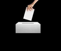 Uma mão a introduzir um papel dobrado dentro de uma caixa. Fundo preto.