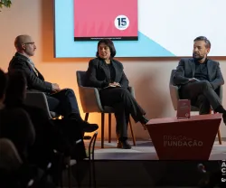 Dois homens e uma mulher sentados, em palco, à conversa sobre o livro da Fundação, que está pousado numa mesa entre eles