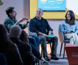 Uma plateia a assistir a um debate entre os humoristas Cláudio Almeida, Nuno Artur Silva e a economista Cláudia Custódio.