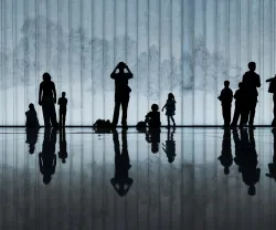 Silhuetas de pessoas de diferentes idades refletidas num paviamento de pedra polida. Crédito Shutterstock com edição de cor FFMS