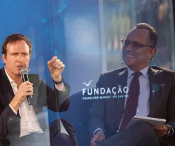 Imagem de duas fotografias sobrepostas: do lado direito o entrevistador, do lado esquerdo, o entrevistado. Ao centro, o logotipo da Fundação.