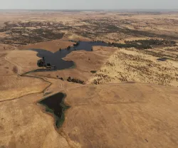 Imagem aérea de vários terrenos áridod r algumas manchas de água.