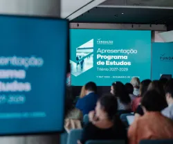 Dezenas de pessoas estão sentadas frente a um ecrã onde se lê  a frase: apresentação do Programa de Estudos da Fundação.