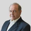 Retrato de António Costa Silva, antigo ministro da Economia e do Mar, sobre um fundo cinzento claro.